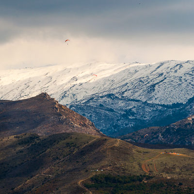 Paragliders in front of the Sierra Nevada.